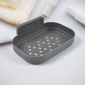 Wall-mounted dark gray soap dish with perforated drainage tray and raised back lip