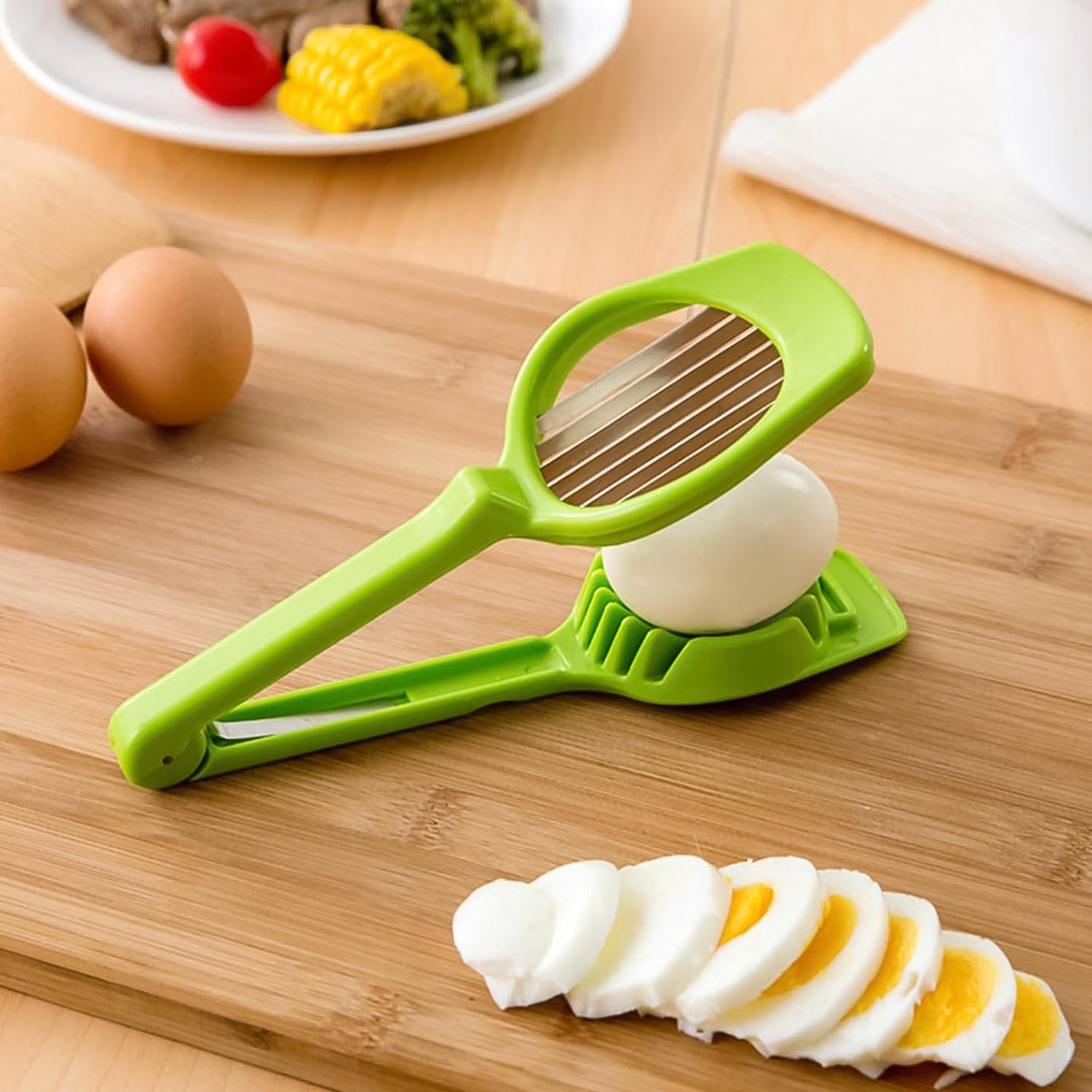 Green vegetable slicer with steel blade, onion slices on wooden cutting board