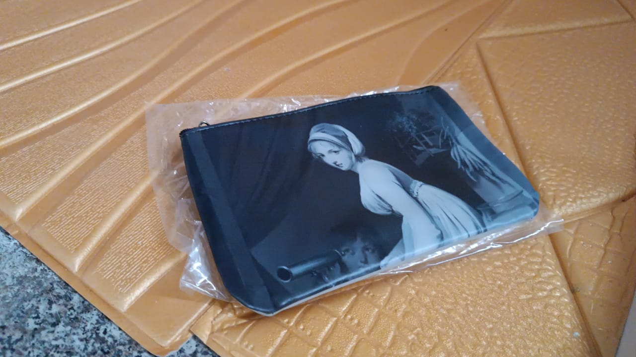 Black travel pouch with monochrome print inside clear protective sleeve