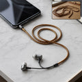 Spiral ribbed cord protector sleeve with wired earbuds and brown coiled earphone cable
