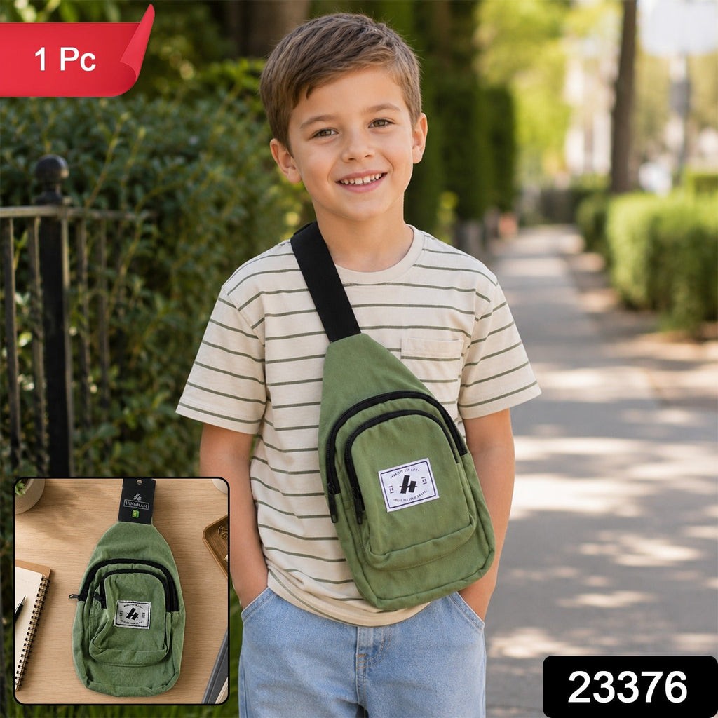 Kids green canvas sling crossbody chest bag worn across chest with front zip pocket