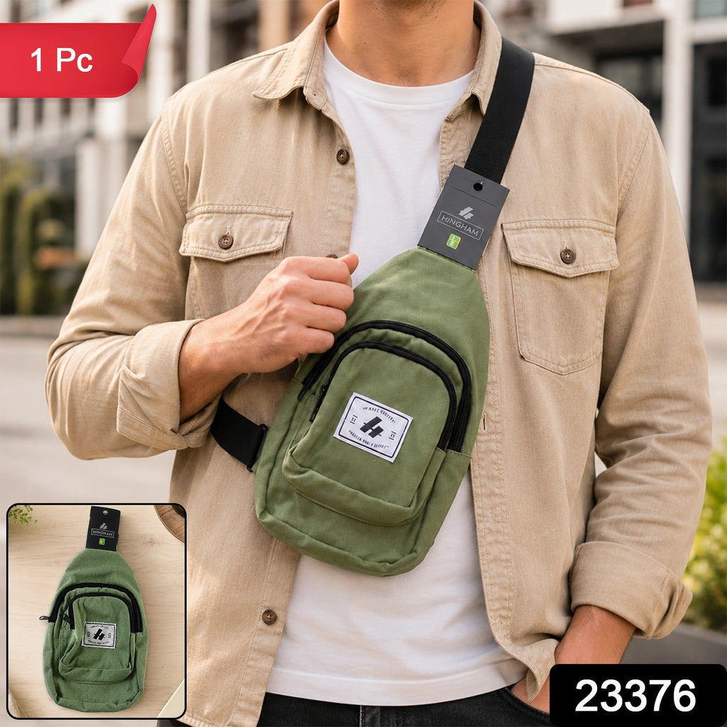 Men’s green canvas crossbody sling bag with front zip pocket, label patch, and black strap