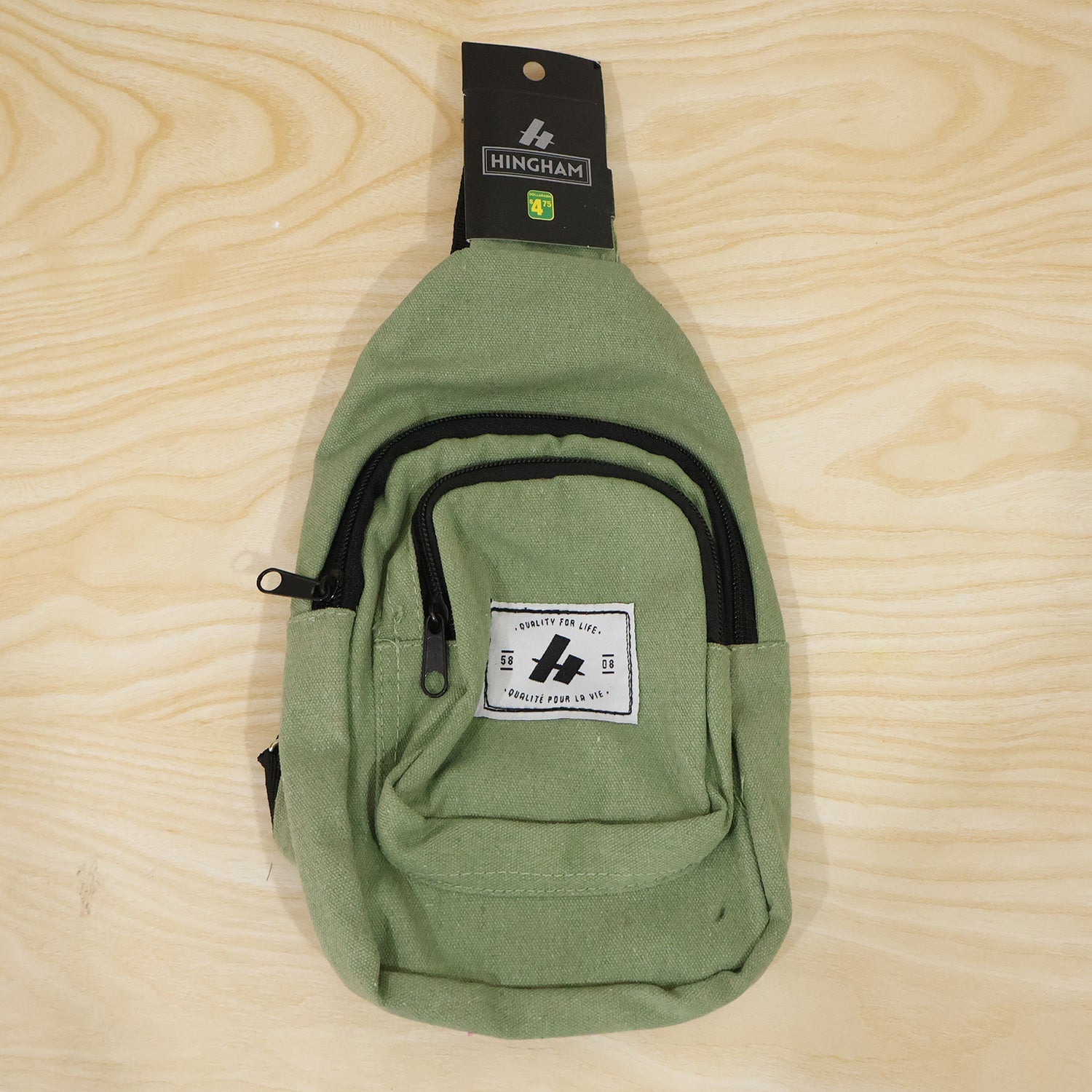 Green canvas kids sling crossbody chest bag front view with small zip pocket