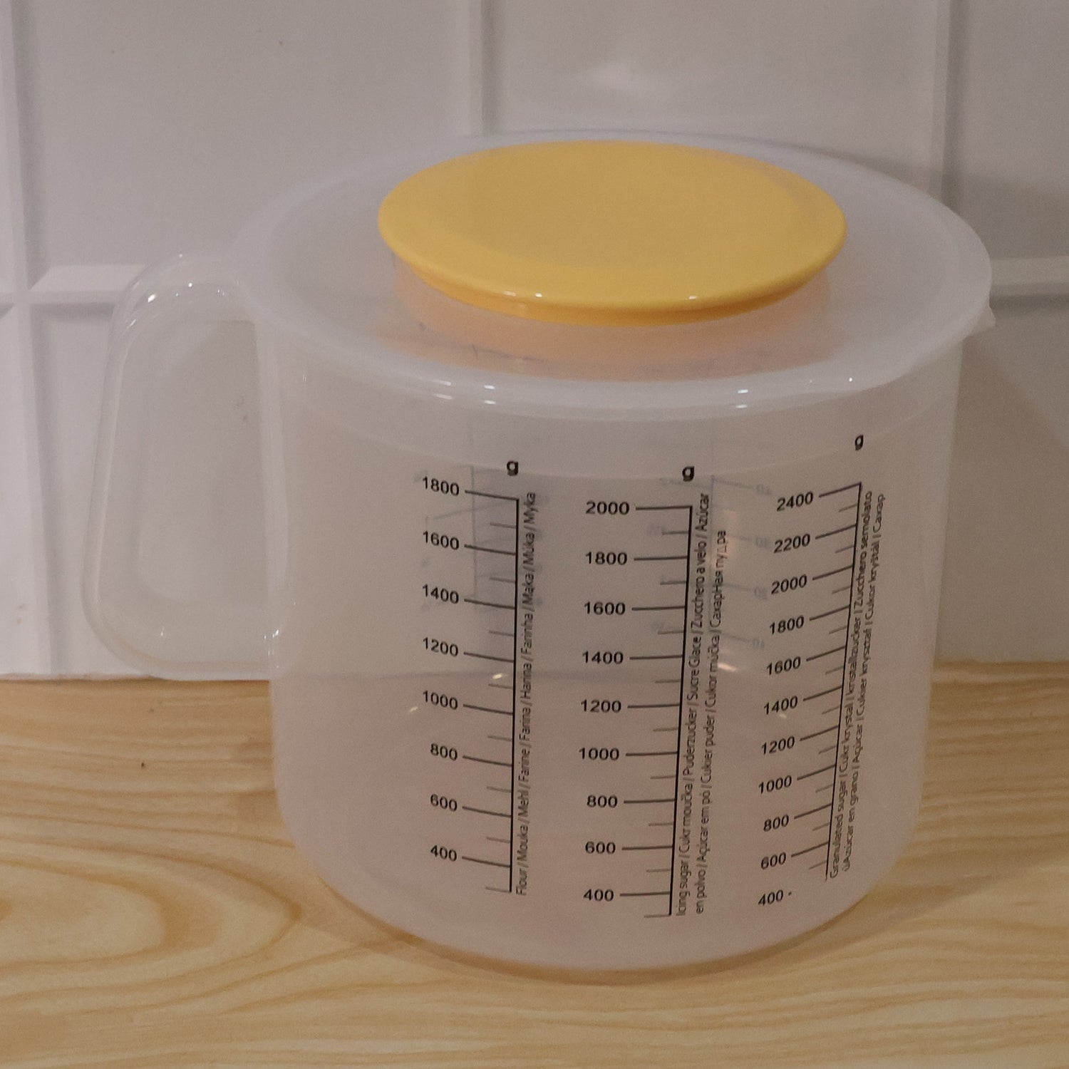 Large clear plastic measurement storage box with printed scale and yellow screw lid
