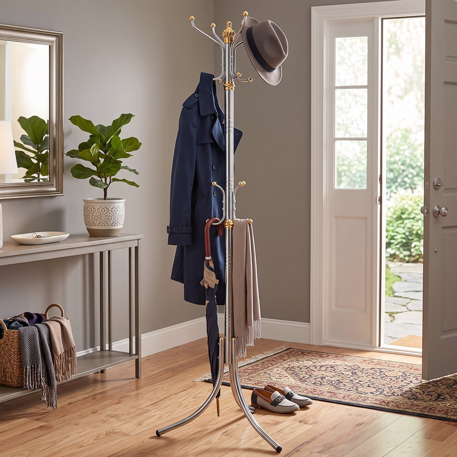 Silver metal coat rack with gold top hooks, hanging dark coats, scarf, and bags