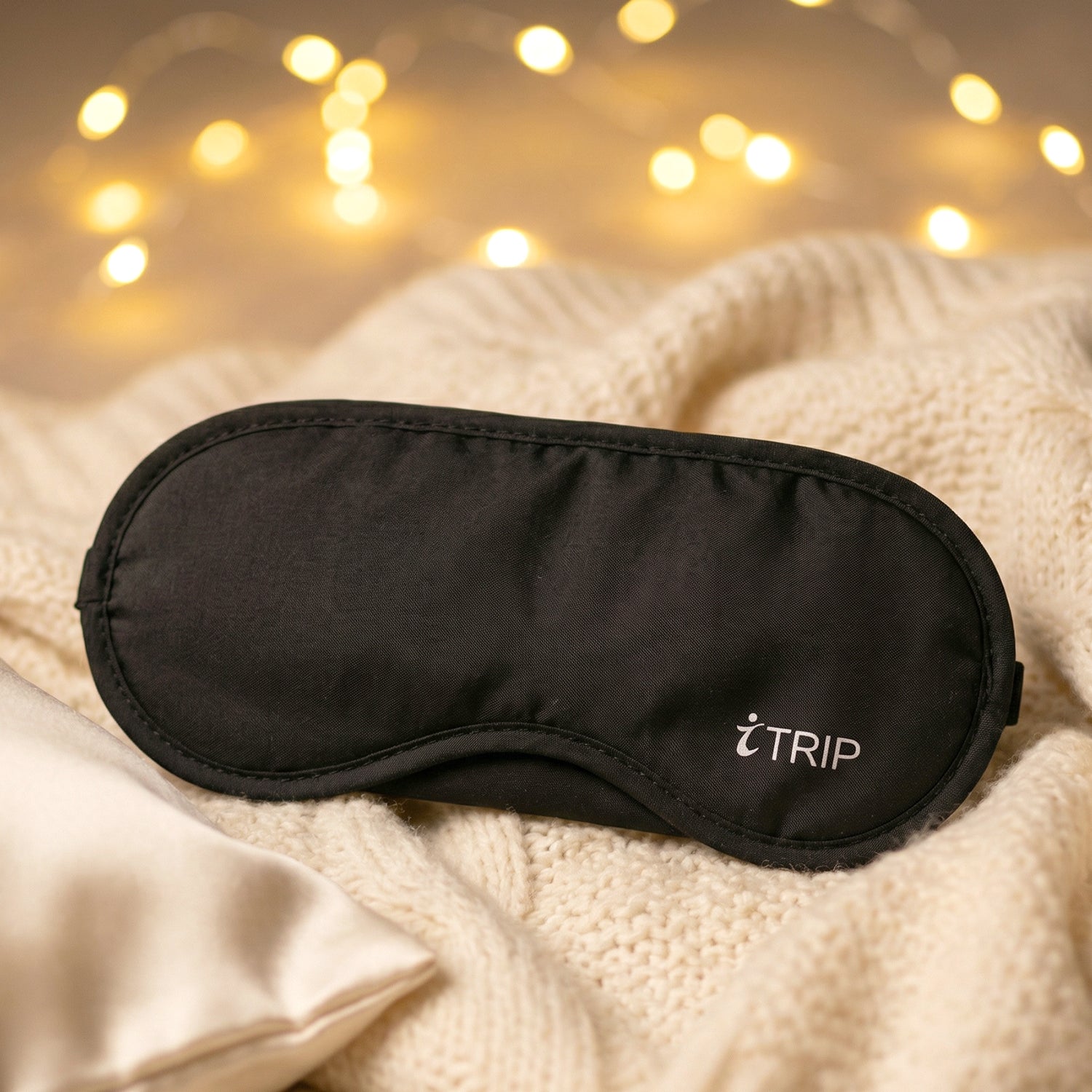 Black padded light-blocking sleep eye mask with logo on front