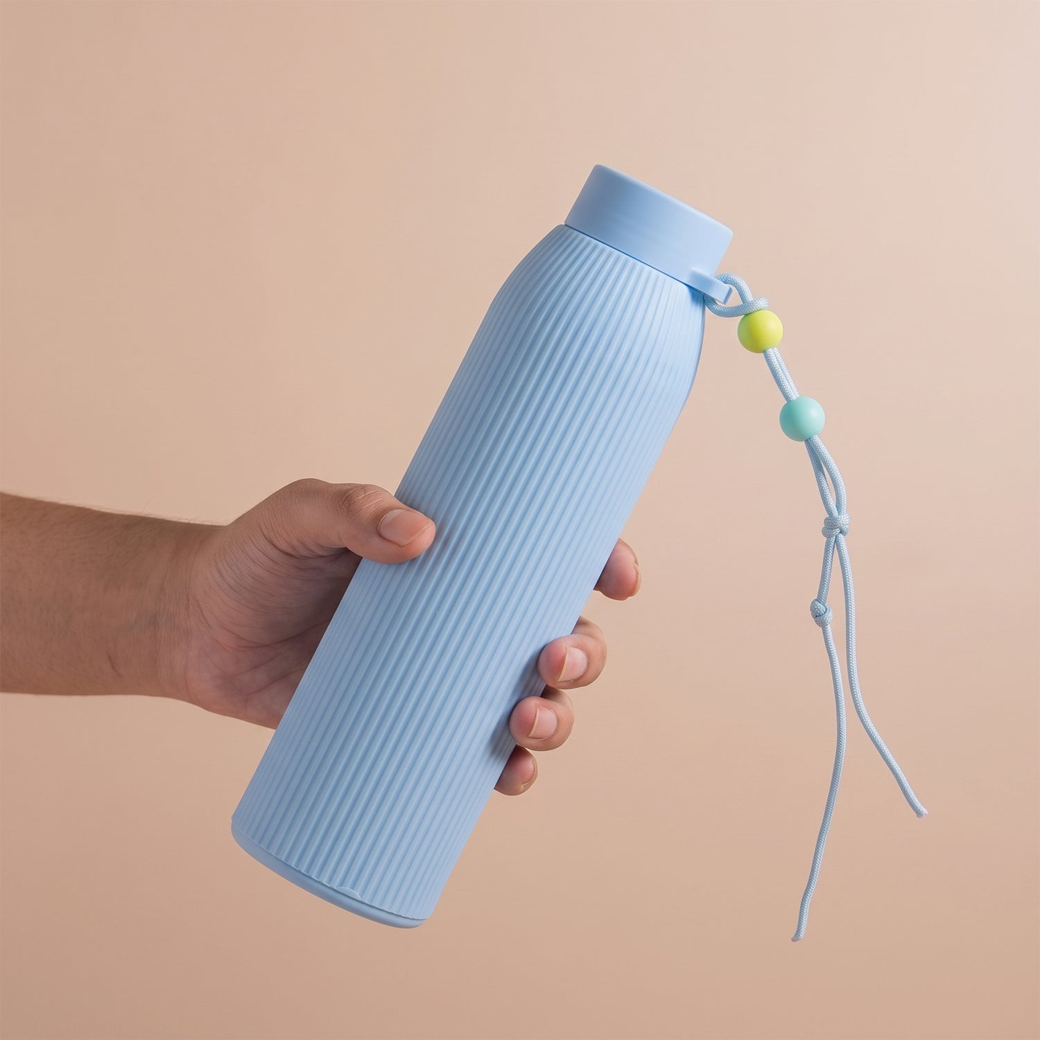 Light blue ribbed glass water bottle with silicone lid and beaded carry cord