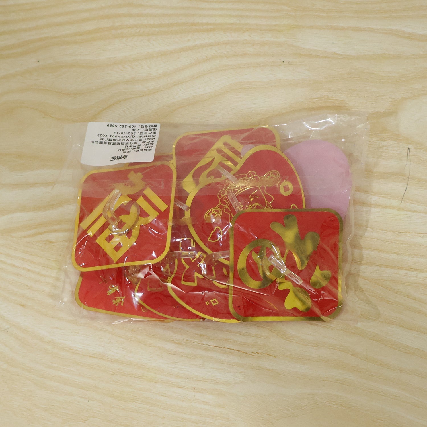 Packaged self-adhesive decorative key hook set, red and gold hooks in plastic wrap