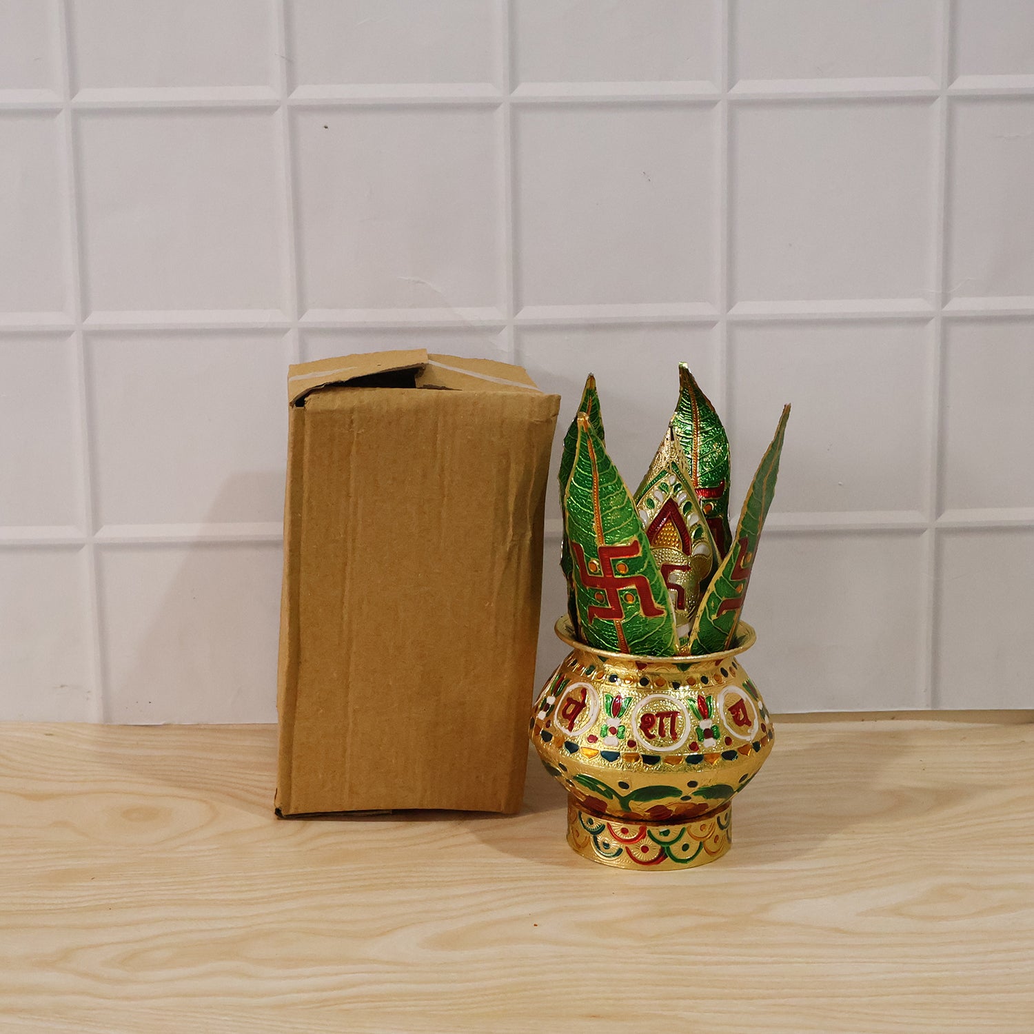 Pooja kalash with green lotus crown beside a plain brown box packaging