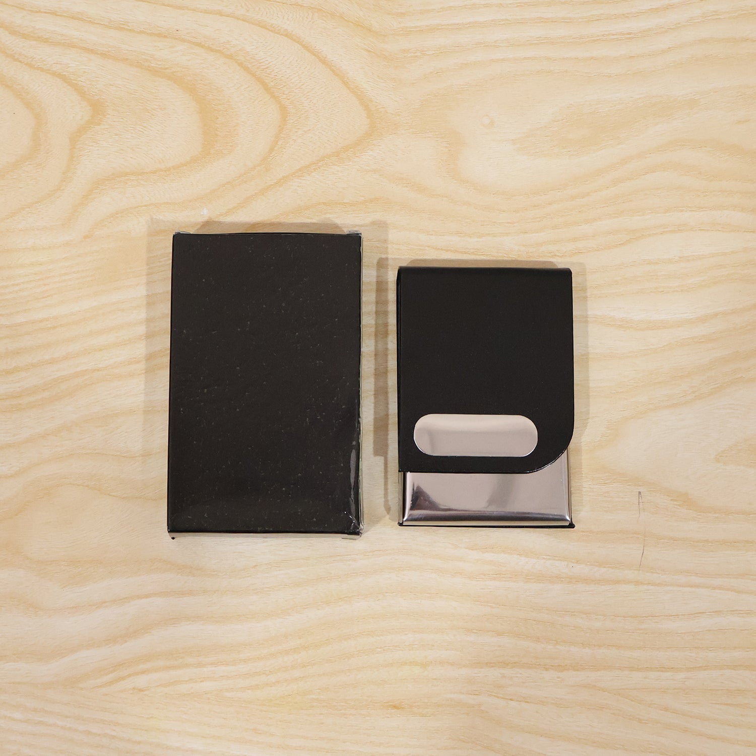 Black leather business card holder set, one closed and one showing oval card slot