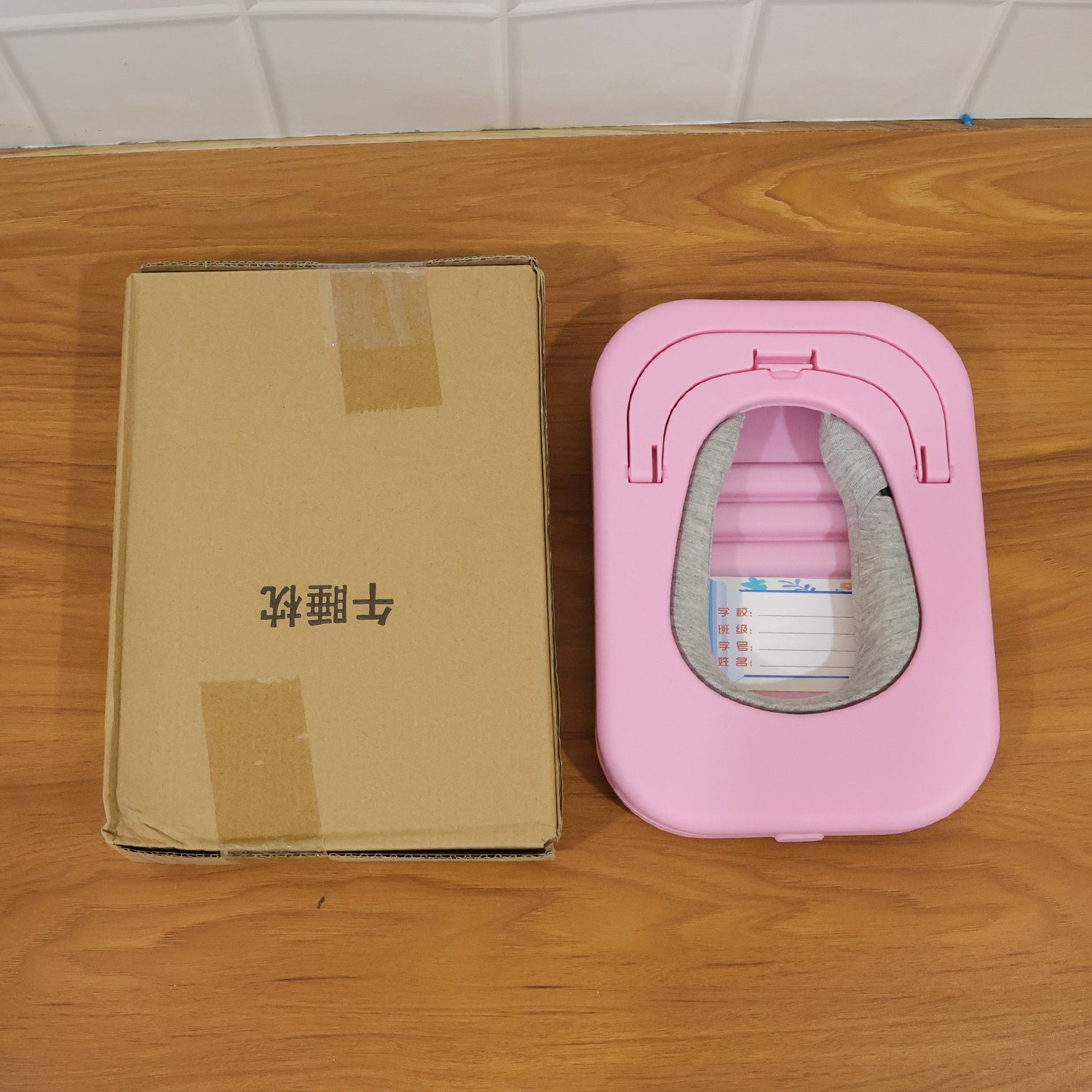 Pink foldable donut neck support cushion with curved inner opening and snap handle