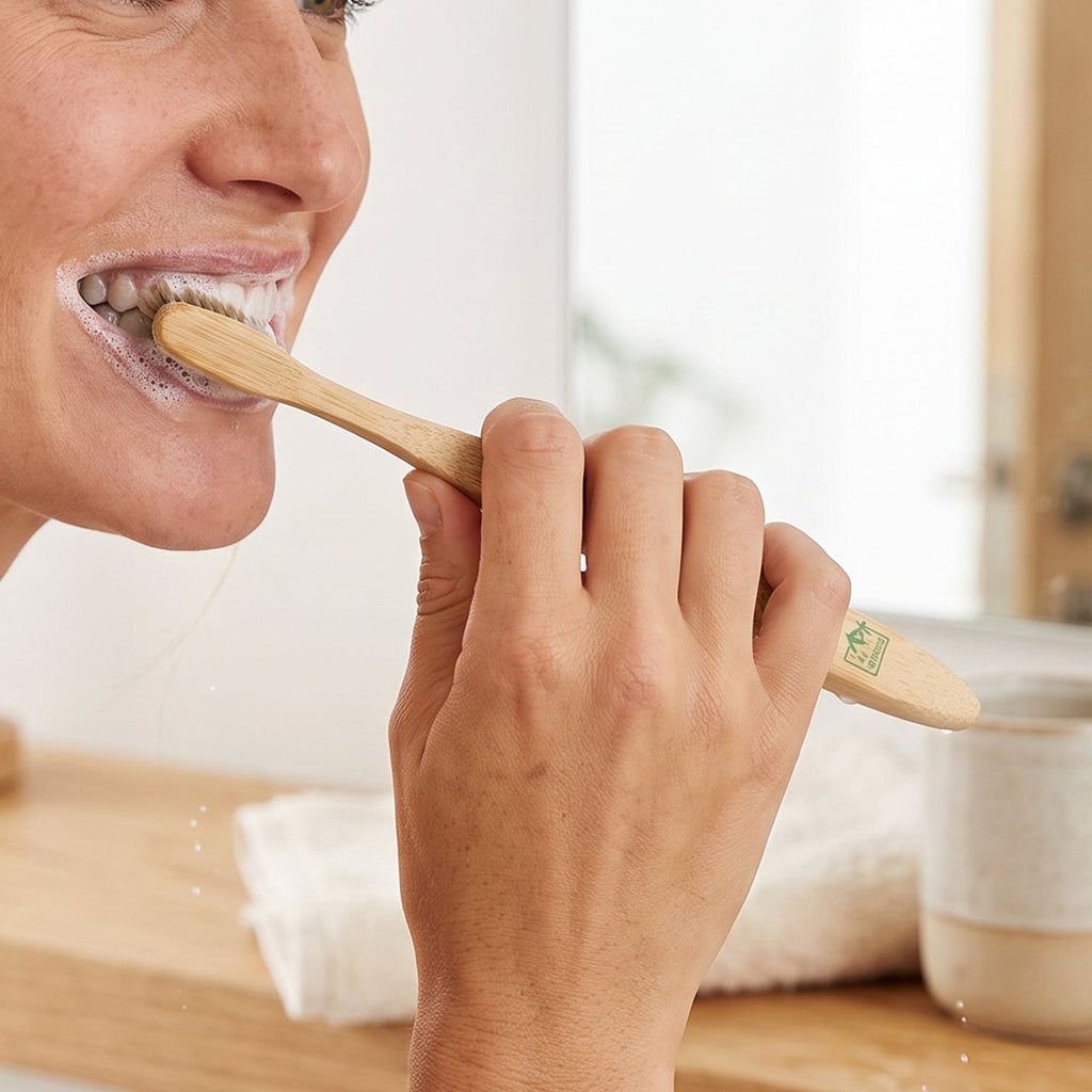Bamboo toothbrush with soft bristles, wooden handle being used to brush teeth