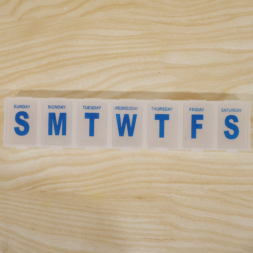 Close-up of 7-day pill organizer lid with blue Sunday to Saturday labels
