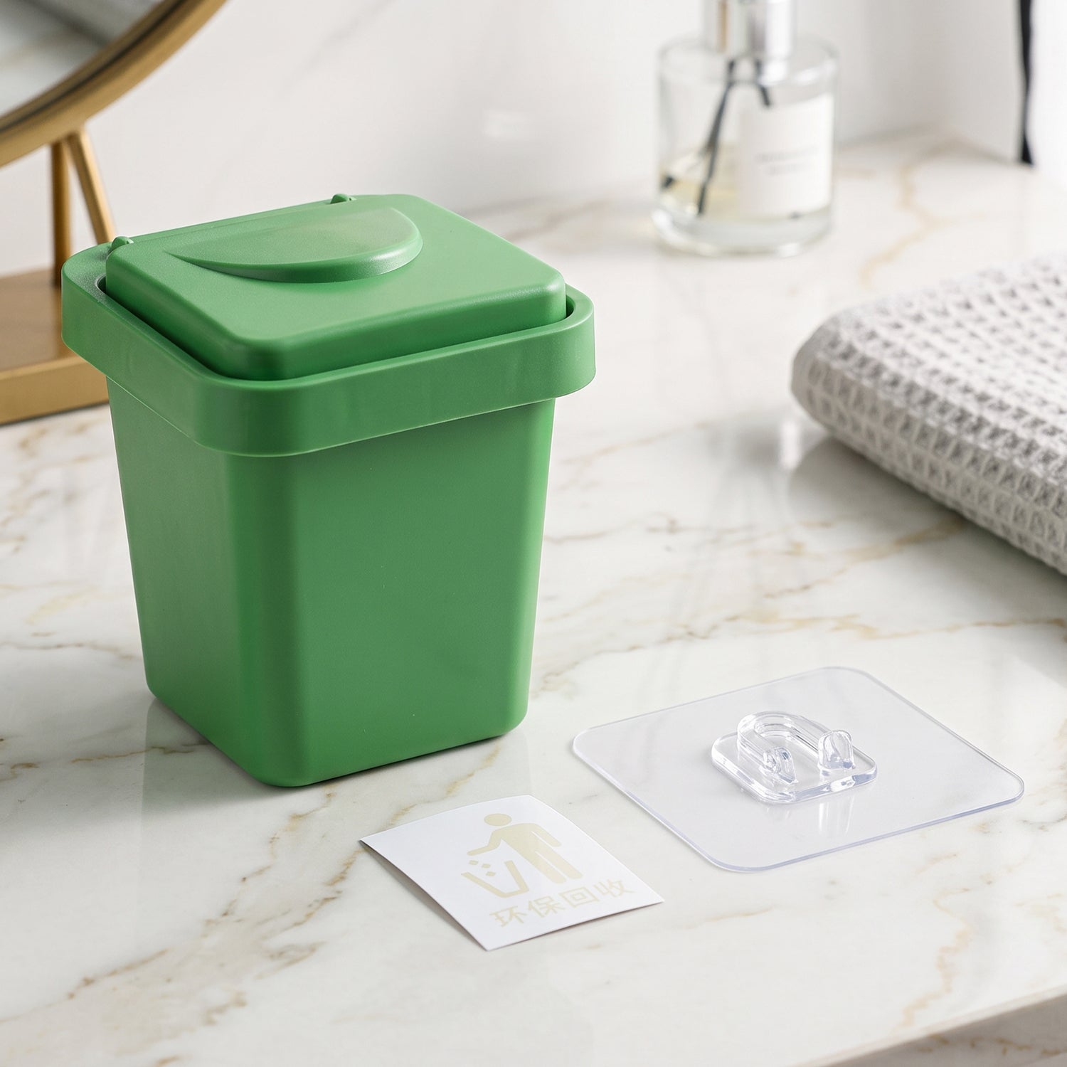 Green mini dustbin ashtray with flip lid closed and clear inner tray on tabletop