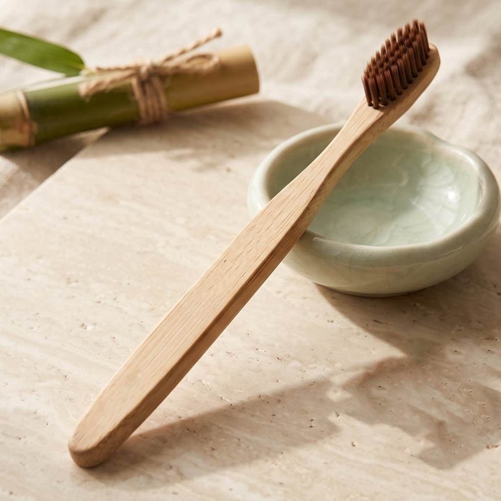 Bamboo toothbrush with soft brown bristles and engraved handle on countertop