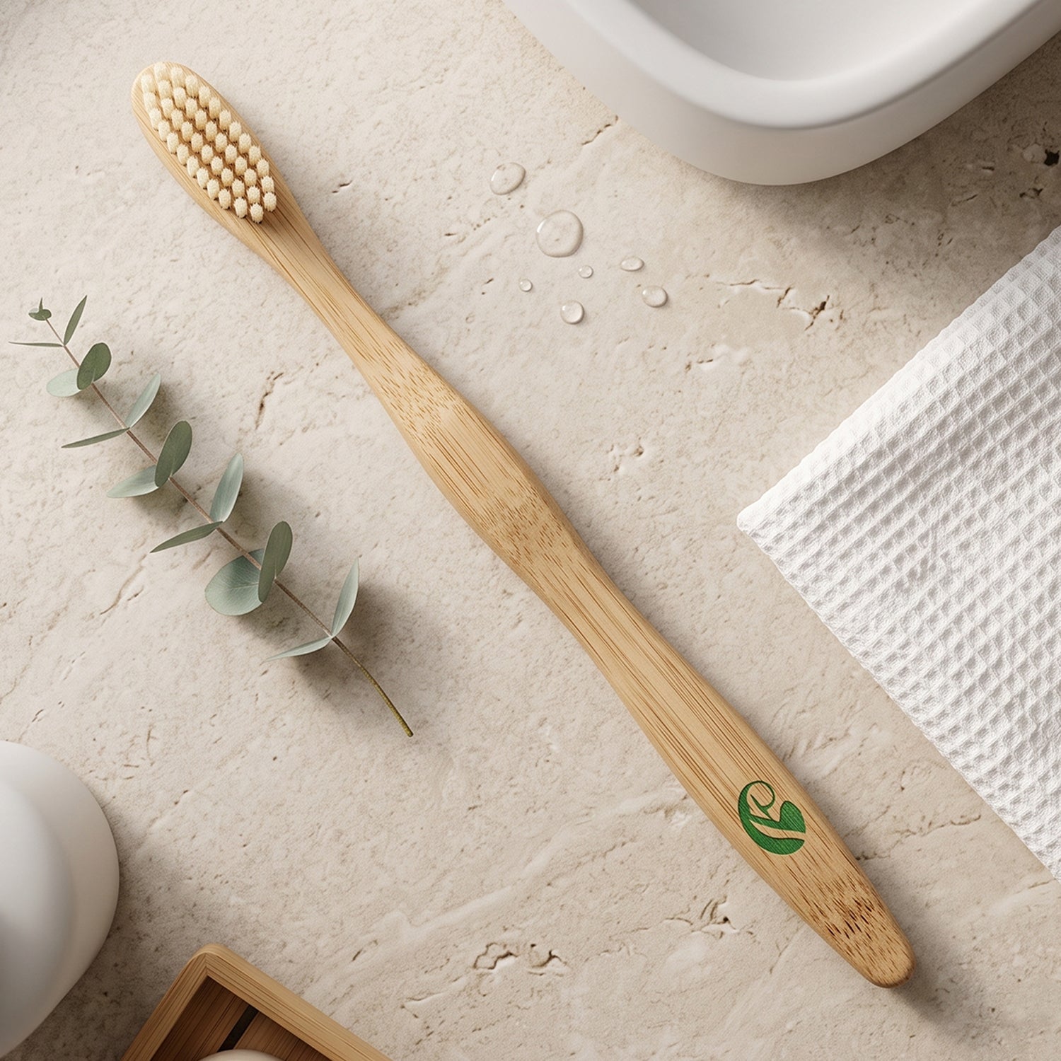 Bamboo toothbrush with natural bristles and green leaf logo on handle