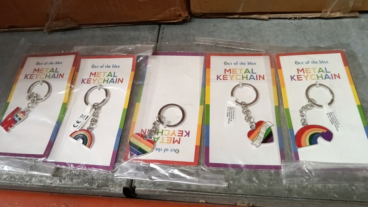 Metal keyring with heart-shaped rainbow charm, shown on retail card packaging