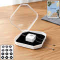 White jewelry storage box with clear lid and black cushion holding necklace and ring