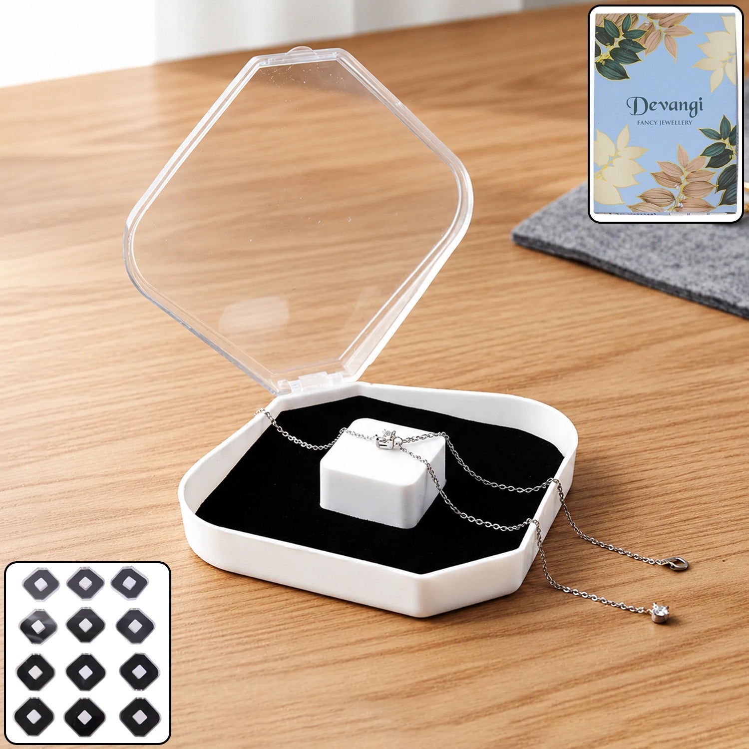 White jewelry storage box with clear lid and black cushion holding necklace and ring
