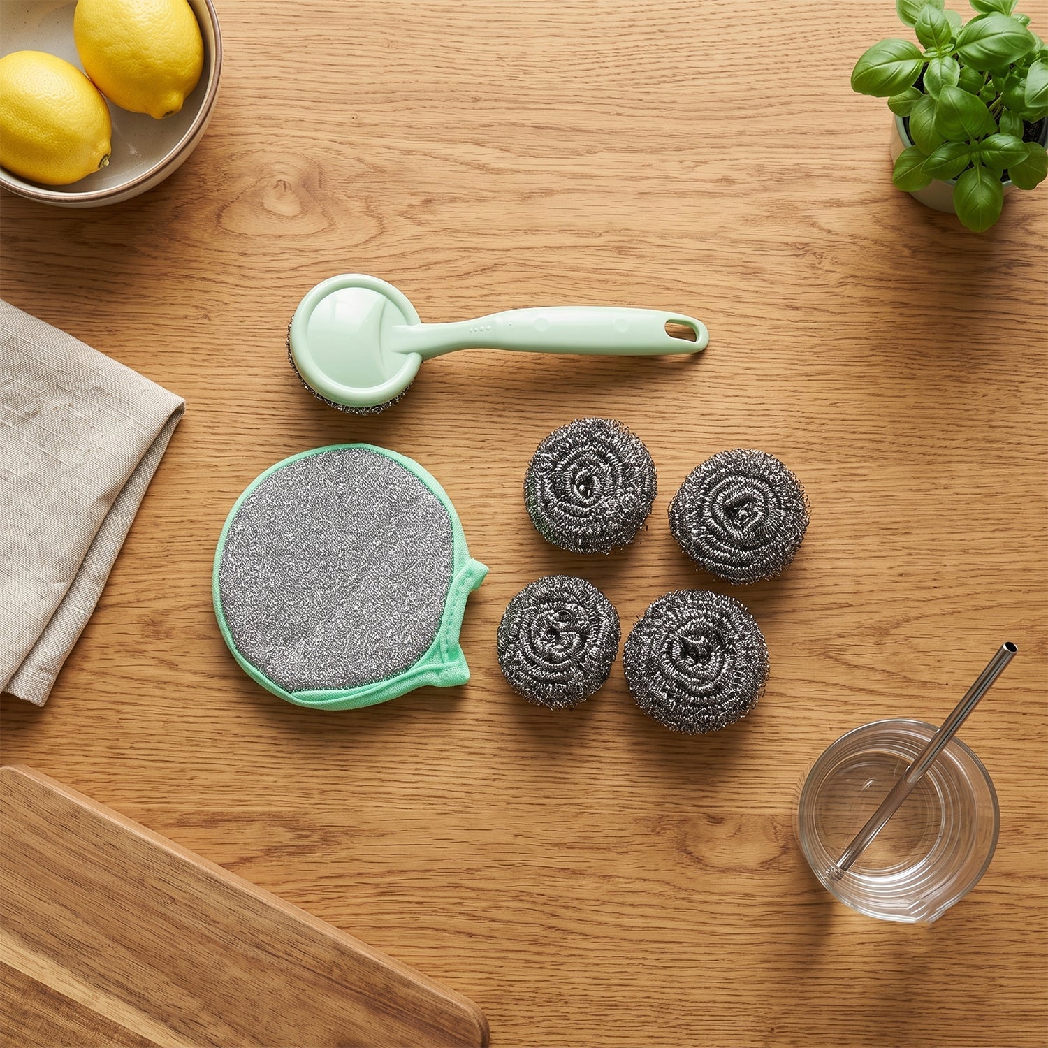 Stainless steel scrubber set with mint handle, large gray pad, and four gray metal balls