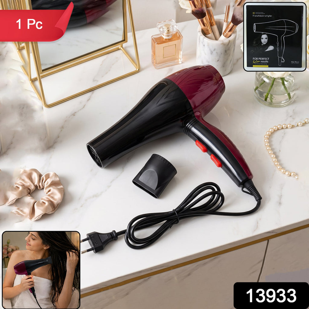 Black and burgundy hair dryer with concentrator nozzle, cord, and red switch