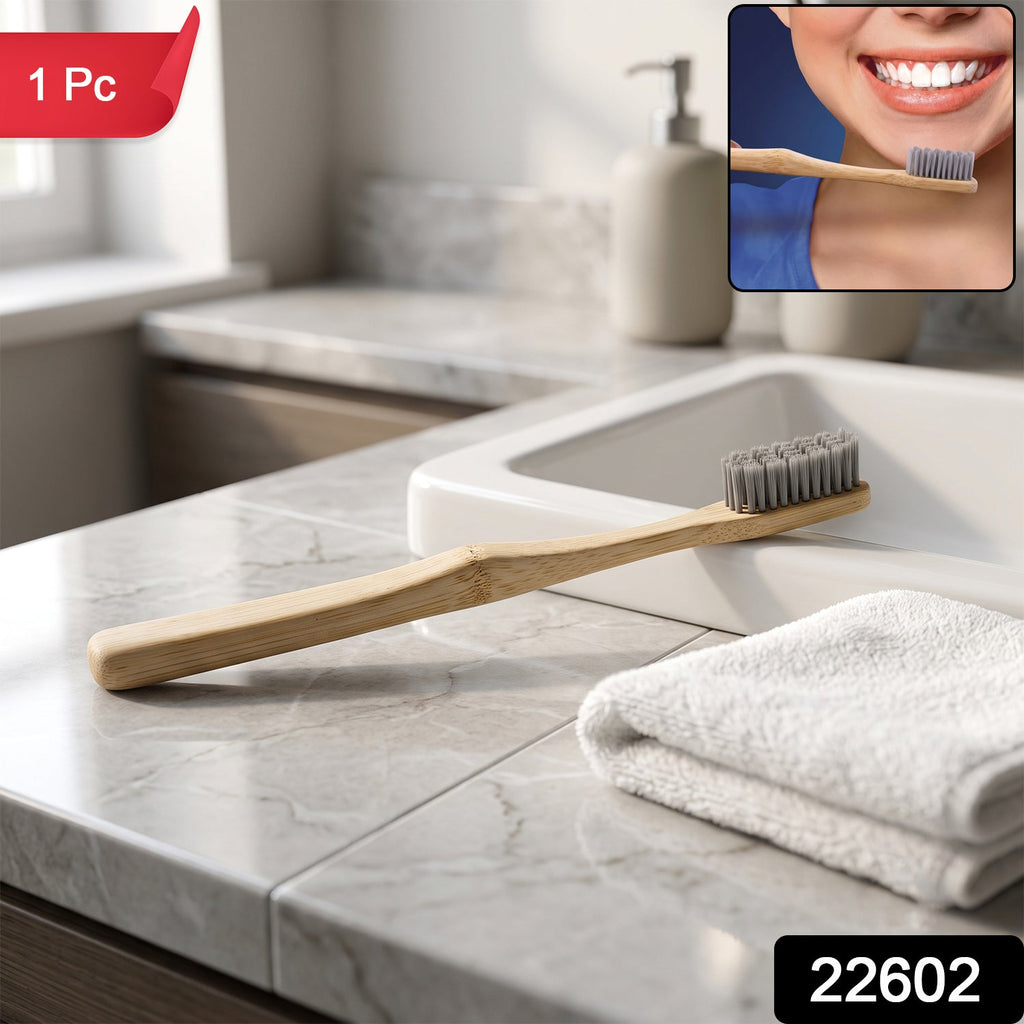 Bamboo toothbrush with soft gray bristles and wooden handle, on sink counter