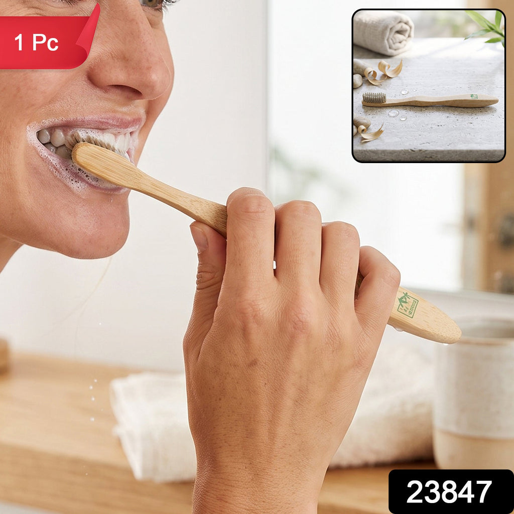 Bamboo toothbrush with soft bristles for travel, hand holding the wooden handle